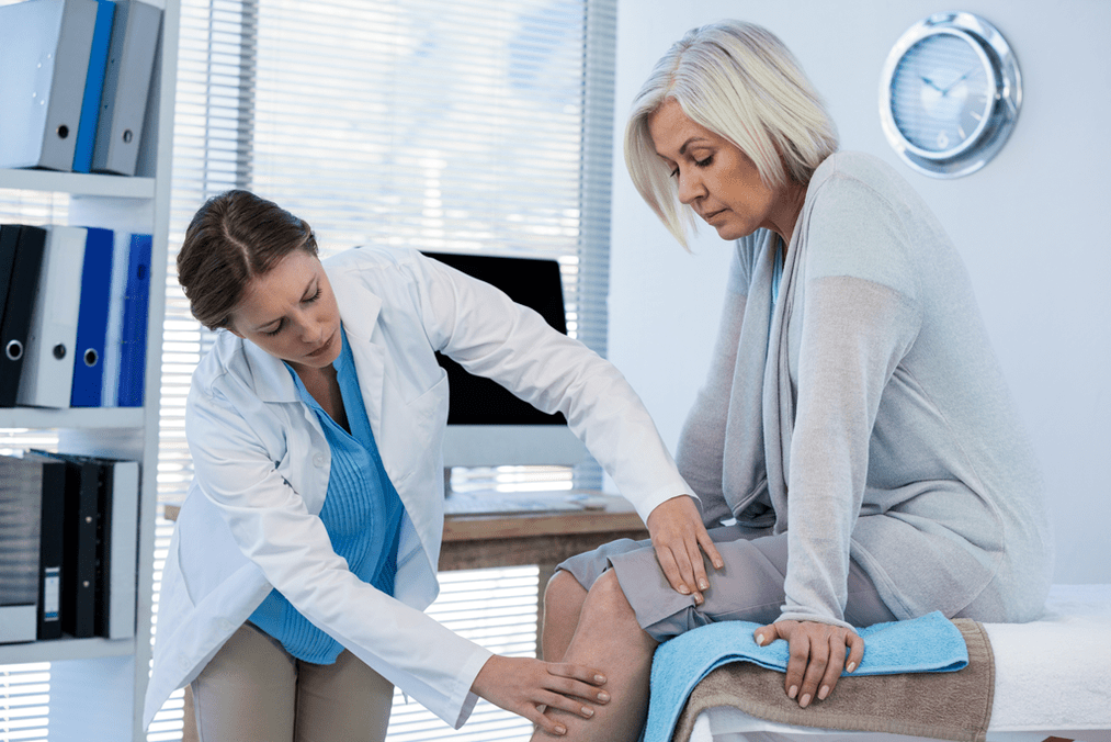 Le médecin examine un patient souffrant d'arthrose de l'articulation du genou. 